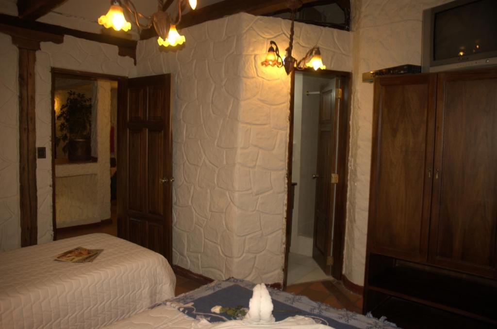 Postel nebo postele na pokoji v ubytování HOTEL Quito Antiguo