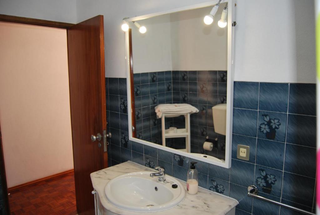 uma casa de banho com um lavatório e um espelho em Apartamentos Mota na Nazaré