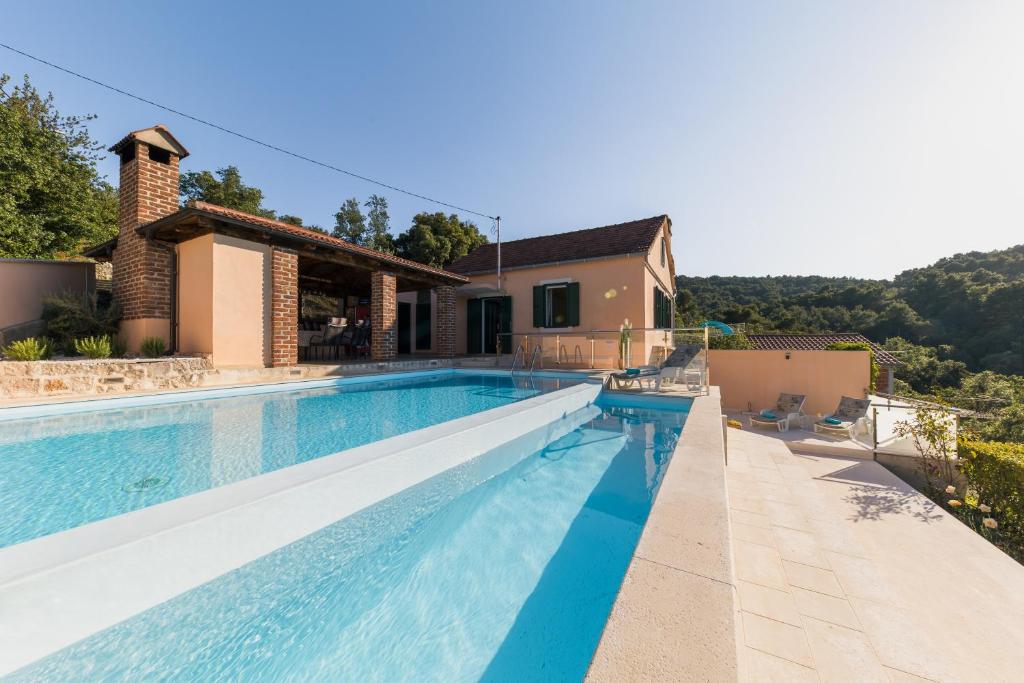 a villa with a swimming pool and a house at Holiday Home Lavanda in Iž Mali