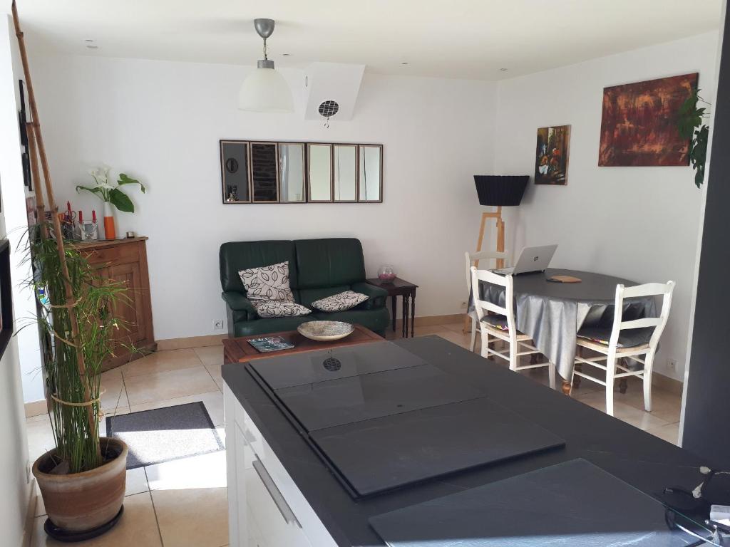une cuisine et un salon avec une table et un canapé dans l'établissement Maison d'hôte très calme plein centre ville jardin, à Moëlan-sur-Mer