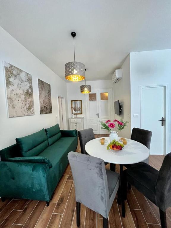 salon z zieloną kanapą i stołem w obiekcie Lux Apartmans w Puli