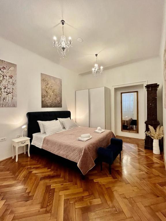 sypialnia z dużym łóżkiem i drewnianą podłogą w obiekcie Lux Apartmans w Puli