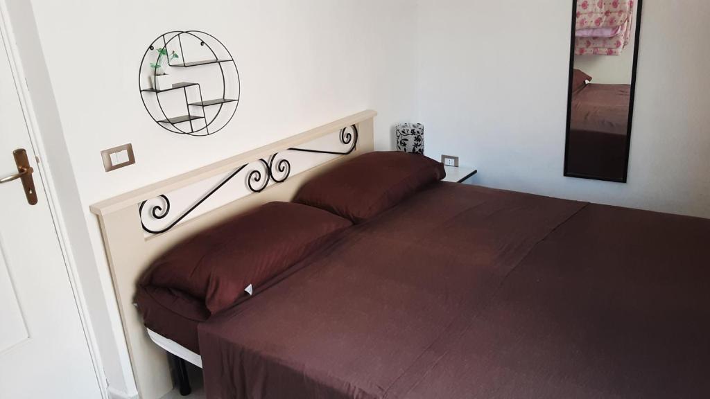 1 dormitorio con 1 cama con colcha marrón en Zia Ciccia en Marsala
