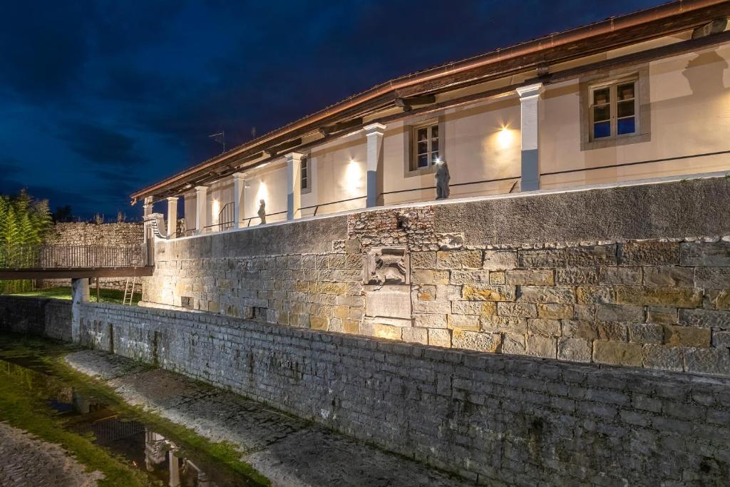 un edificio de piedra con luces en el lateral. en Casa vacanze alle Mura en Cividale del Friuli