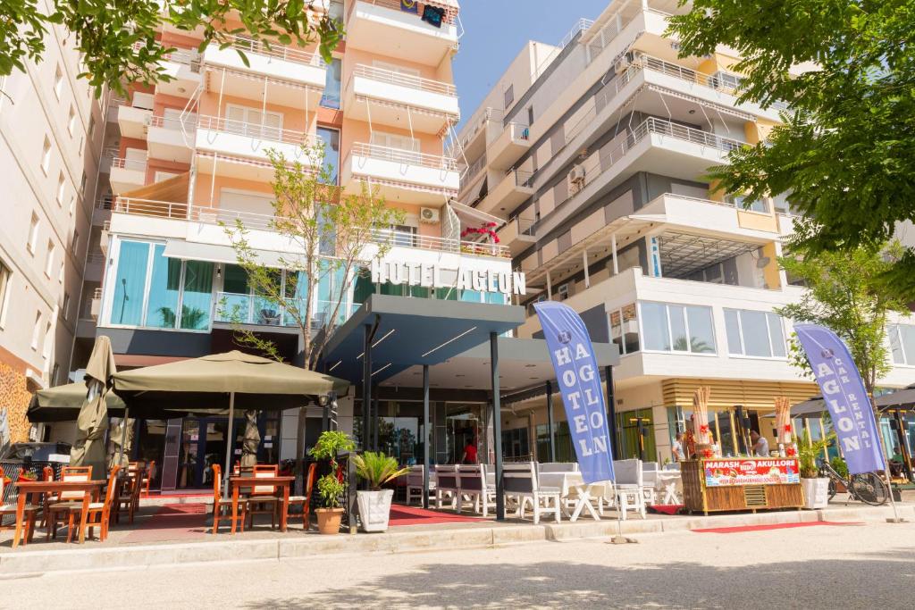 een gebouw met tafels en stoelen ervoor bij Hotel Aglon in Vlorë
