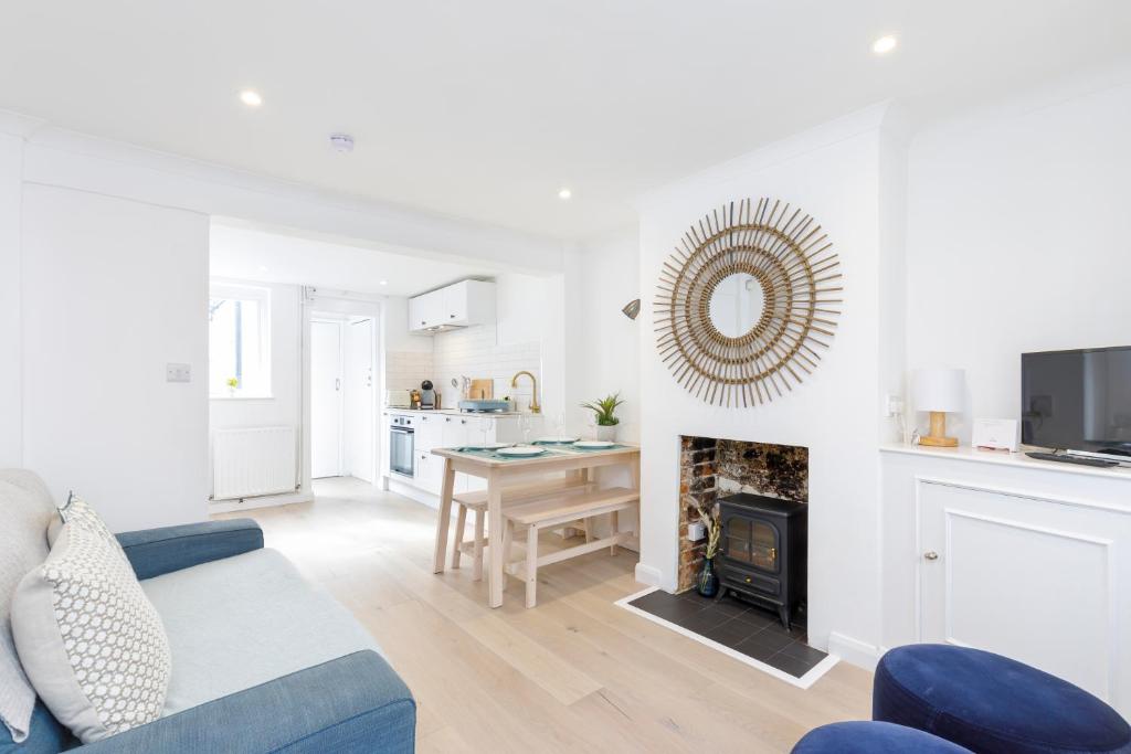 a living room with a blue couch and a fireplace at Central quiet cottage. Walk to shops, bars & beach in Brighton & Hove