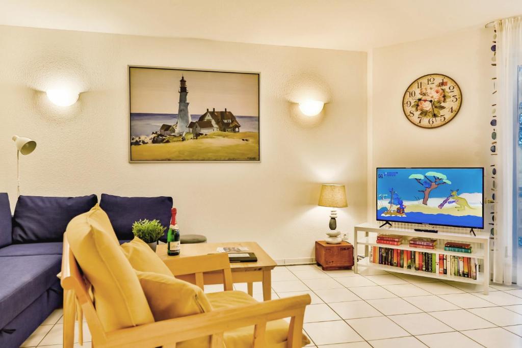 uma sala de estar com um sofá e uma televisão em Apartment Ostseerose ein Strandkorb ist im Sommer inclusive em Zempin