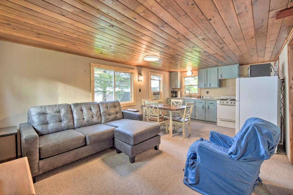 a living room with a couch and a table and a kitchen at Cozy Cabin with Deck and Private Dock on Nelson Lake! in Hayward