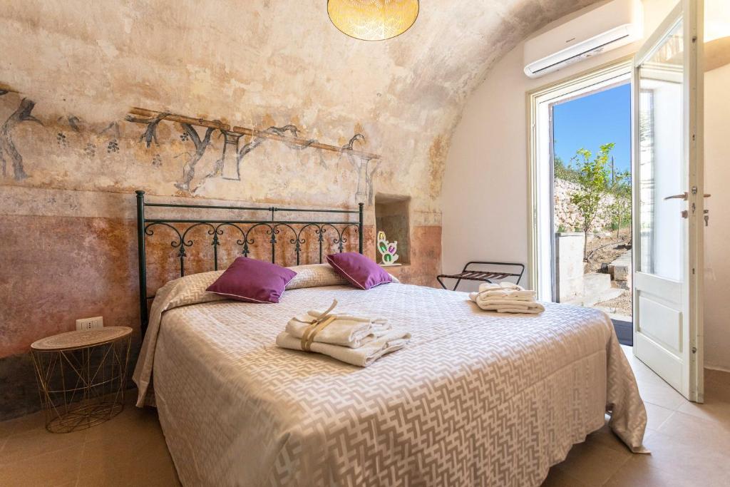 1 dormitorio con 1 cama grande con almohadas moradas en Dimora la Pinta ‘700, en Gallipoli