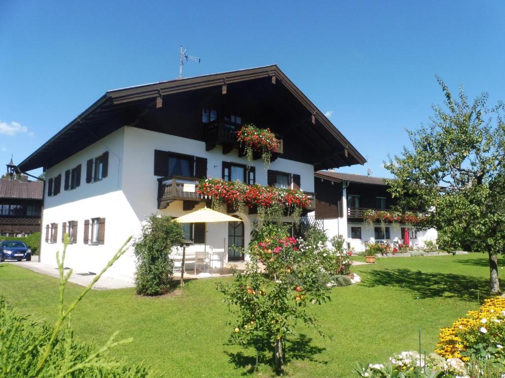 a white building with a black roof at Ferienwohnung Wennesz 2 in Chieming