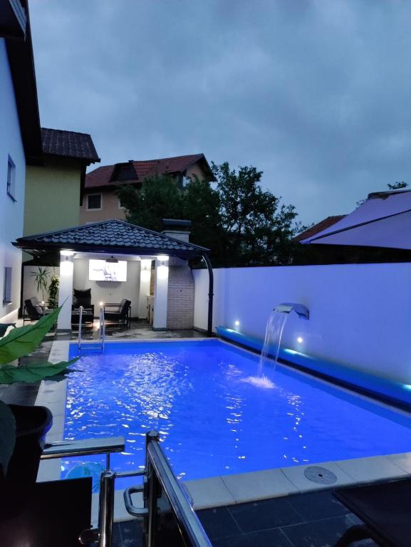 a large blue swimming pool with a water fountain at Apartman Kiss in Jajce