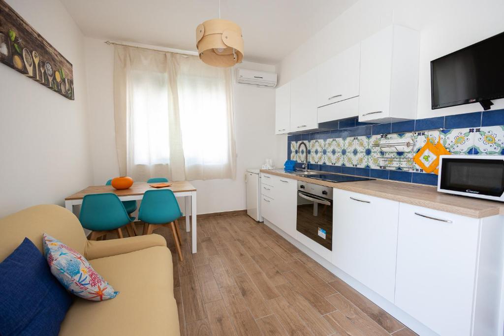 uma cozinha e sala de estar com um sofá e uma mesa em Leo House em Porto Cesareo