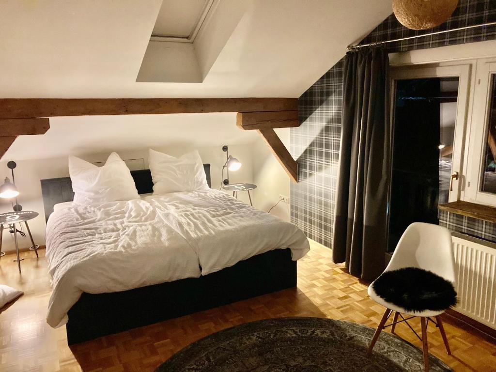 CHALET OSERIAN in Bad Gastein في باد جاستاين: غرفة نوم بسرير كبير وكرسي