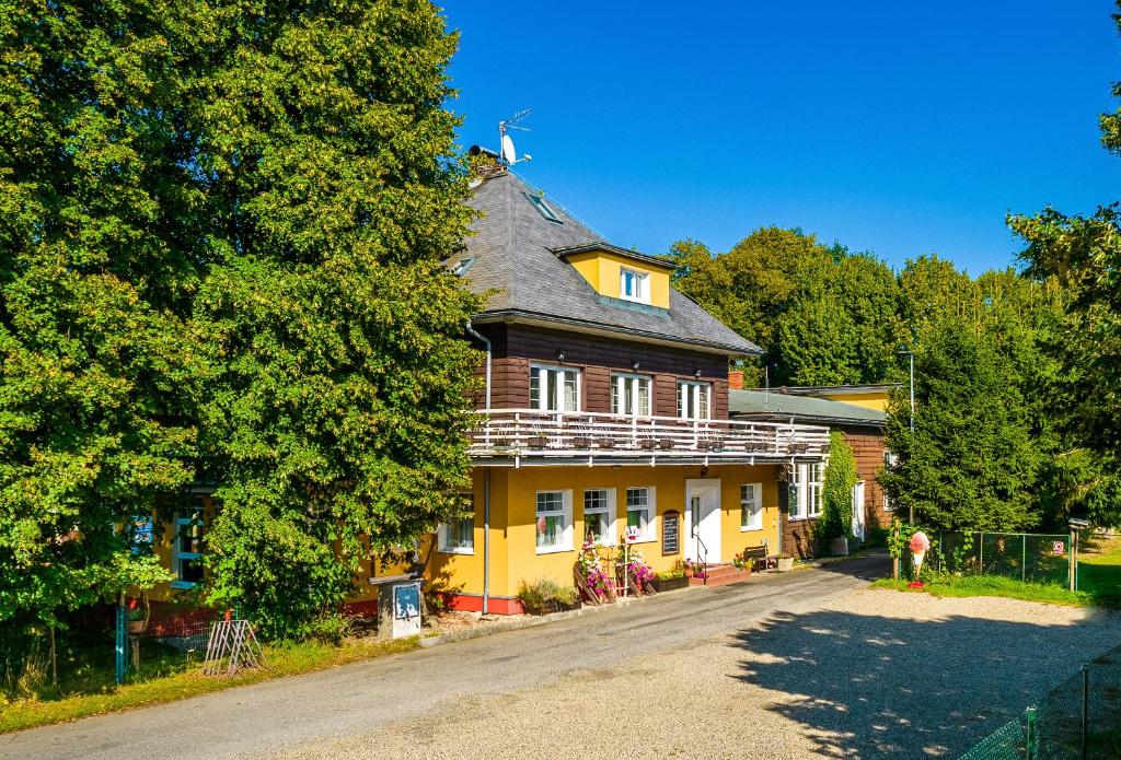 ein großes gelbes Haus mit einem Gameradach in der Unterkunft Hotel Sonnenhof/Slavia in Horní Podluží
