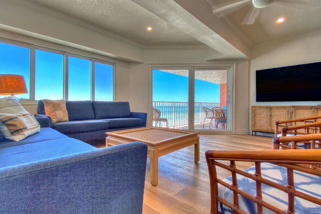 un salon avec un canapé bleu et une télévision dans l'établissement Beach Cottage 1508, à Clearwater Beach
