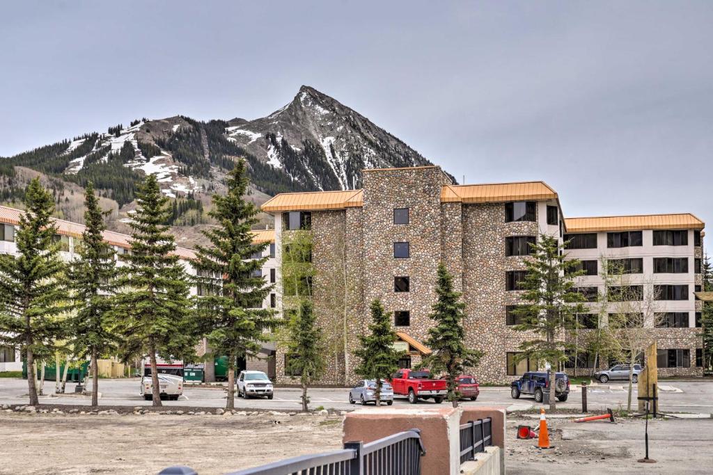 a large building with a mountain in the background at Crested Butte Studio with Community Hot Tub and Pool! in Crested Butte