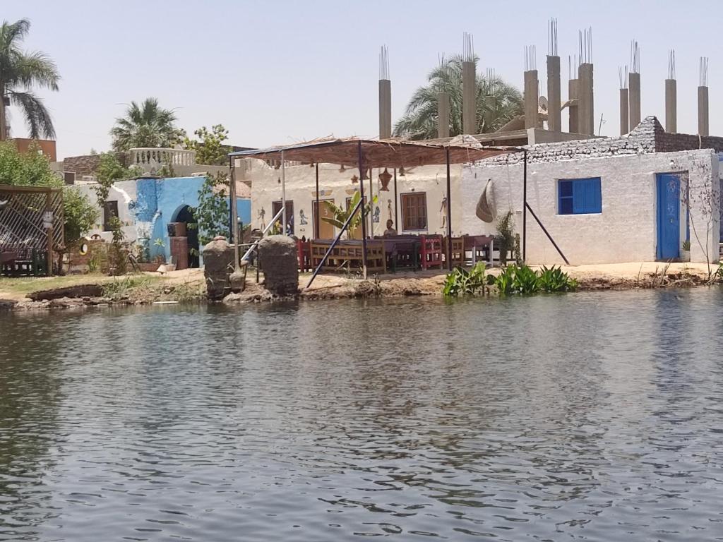 ein Haus an der Seite eines Wasserkörpers in der Unterkunft Luxor Old Nile Hotel in Luxor