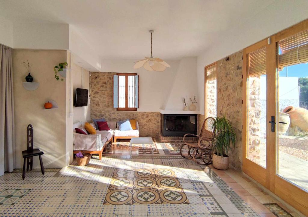 a living room with a couch and a fireplace at Villa Serrano La casa rural de los mil suelos in Valencia