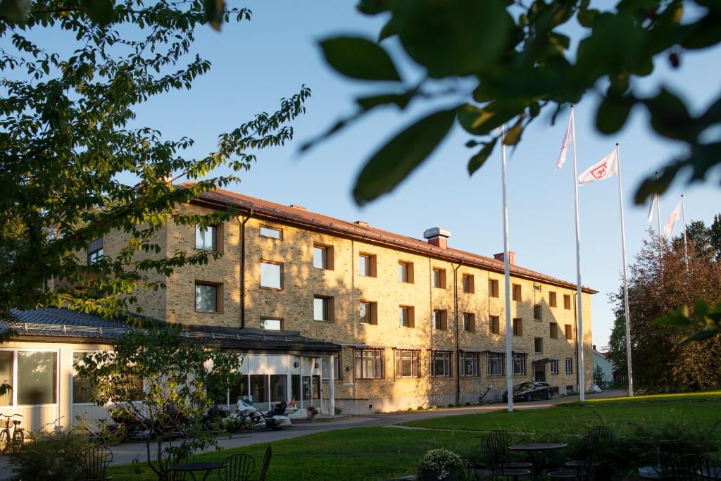 un bâtiment avec deux drapeaux devant lui dans l'établissement Sunderby folkhögskola Hotell & Konferens, à Luleå