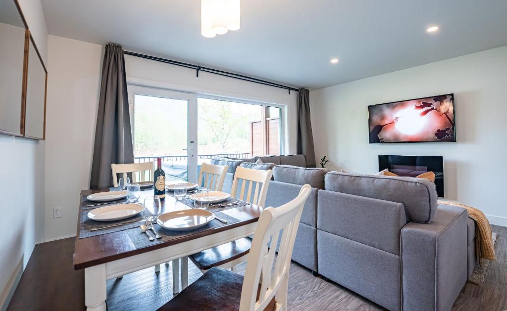a dining room with a table and a couch at RendezView by Revelstoke Vacations in Revelstoke