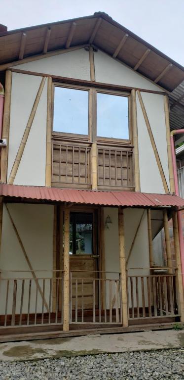una casa con una grande finestra e un portico di Cabaña los Naranjos con parqueo a Calarcá