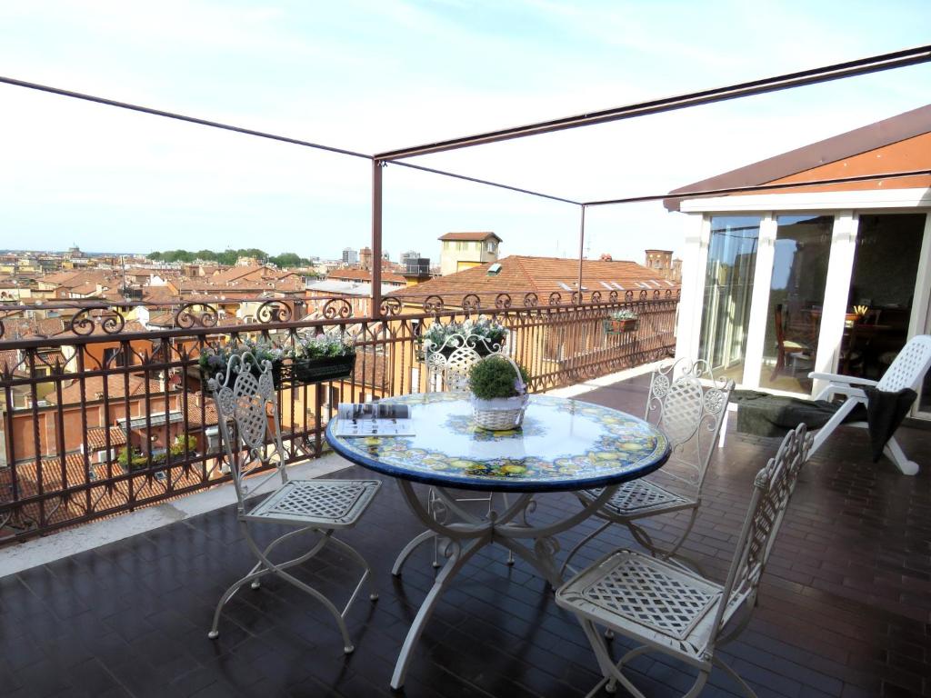een patio met een tafel en stoelen op een balkon bij Montegrappa Apartment in Bologna