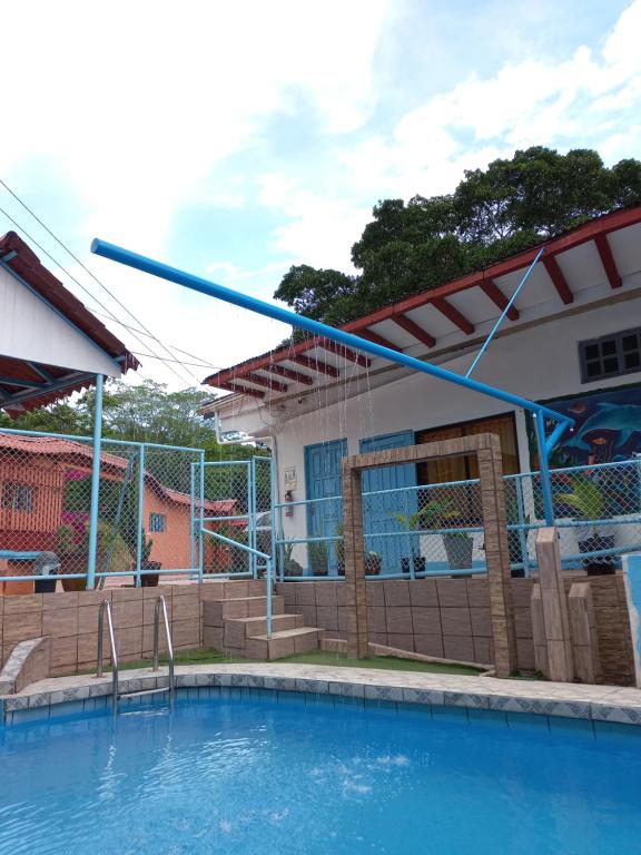 a swimming pool in front of a house at Hotel La Uvita in Puerto Limón