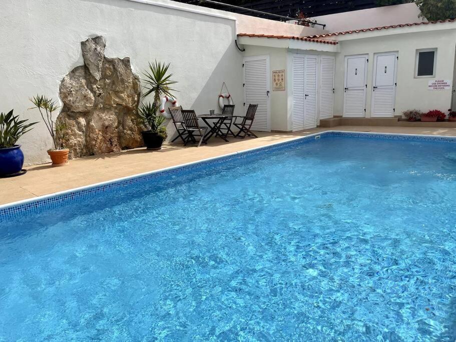 uma grande piscina azul ao lado de uma casa em 2 bed apt mountains and costal views with pool em Pafos