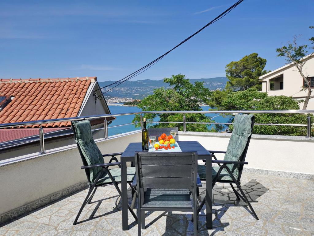 a table and chairs on a balcony with a view of the water at Studio Apartment Glorijeta in Šilo