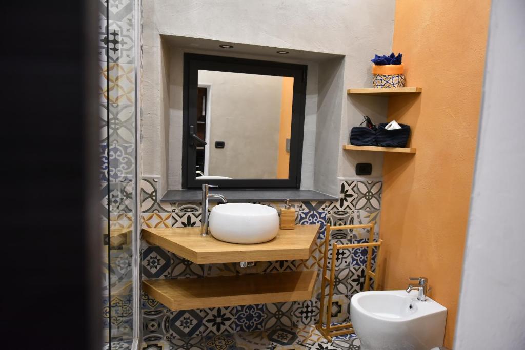 łazienka z umywalką i lustrem w obiekcie Apartments Casa Vacanze Dante w Katanii