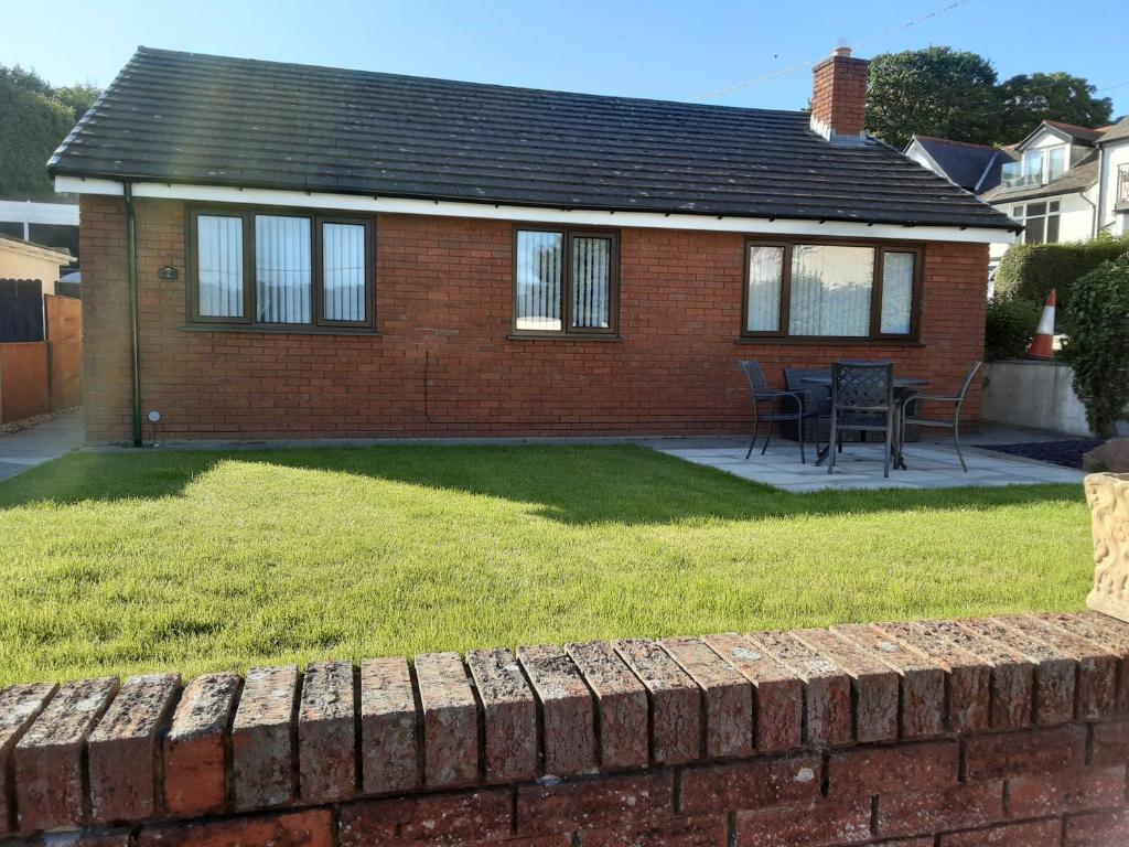 a brick house with a yard and a brick wall at 3-Bed bungalow near Conwy valley close to Castle in Colwyn Bay