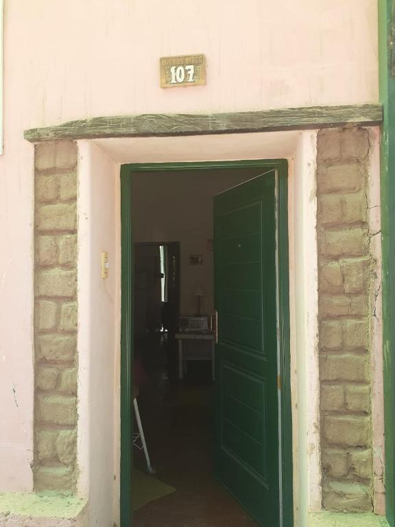 a green door in a room with a brick wall at Casa Chica in Cafayate