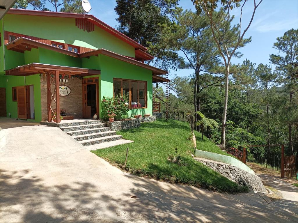 a green house with a pathway in front of it at Mi Hogar Jarabacoa in Jarabacoa