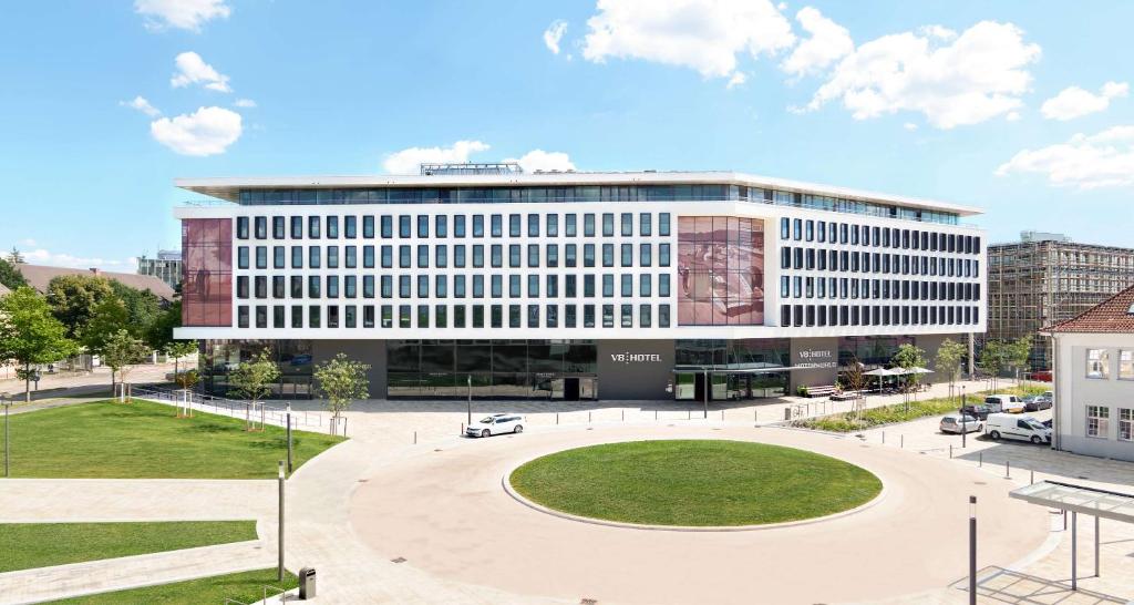 a large office building with a park in front of it at V8 HOTEL Motorworld Region Stuttgart in Böblingen