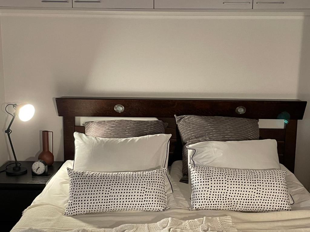 ein Bett mit zwei Kissen und einem Kopfteil aus Holz in der Unterkunft Stunning 1-Bed Apartment in Tampere in Tampere