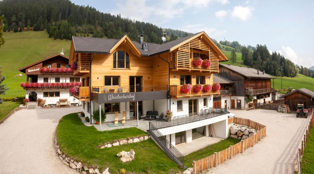 a large wooden house in the middle of a field at Waidacherhof Apartments in Braies