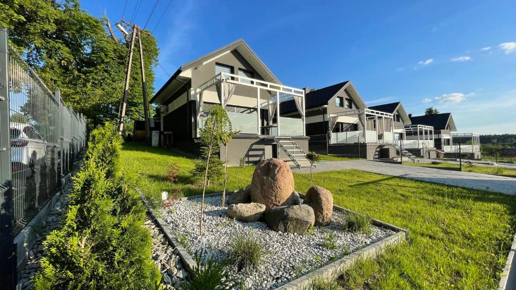 uma casa com um jardim de pedra em frente em Domy na Roztoczu Aleja Lipowa A H em Zwierzyniec