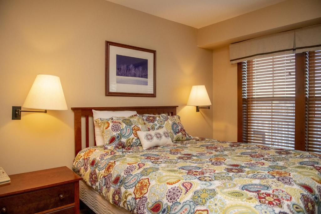 um quarto com uma cama, 2 candeeiros e um telefone em Allegheny Spring 326, ski in out, Pool HotTub em Snowshoe