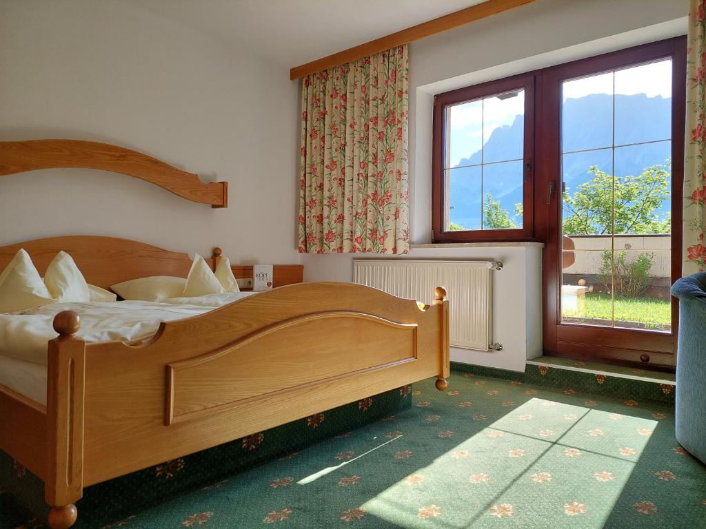 a bedroom with a bed and a large window at Landhaus Gerber in Lermoos