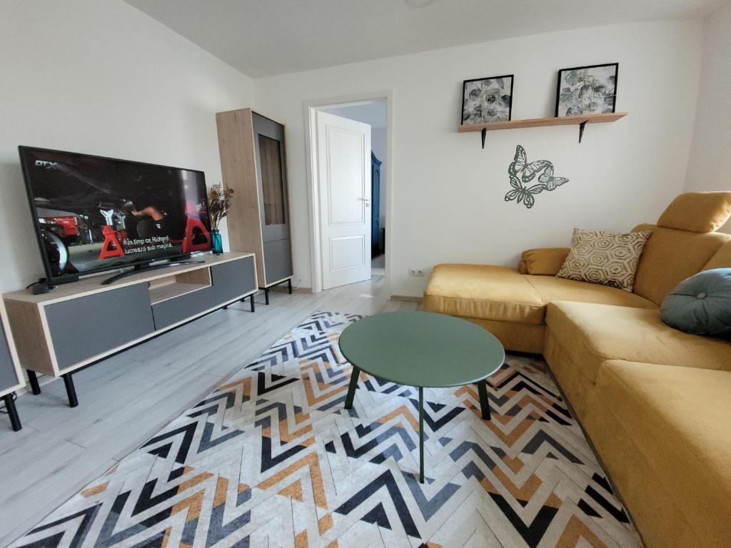 ein Wohnzimmer mit einem Sofa und einem TV in der Unterkunft Lovely Apartment Near City Center (w/ Parking) in Cluj-Napoca