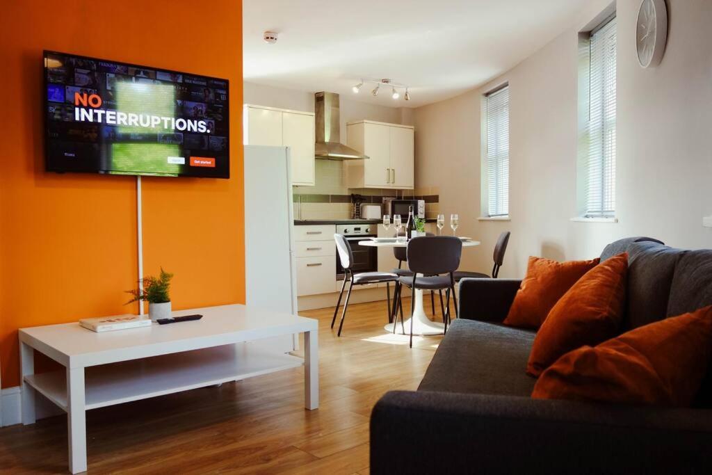 a living room with a couch and a tv on a wall at PRIMEEE LOCATION - Modern Central Apartment in Bristol