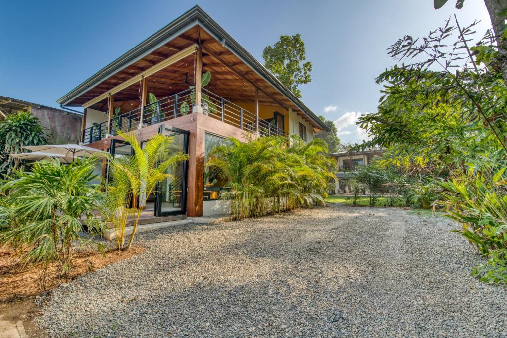 an exterior view of a house with a gravel driveway at Yoshi's on the beach in Cahuita