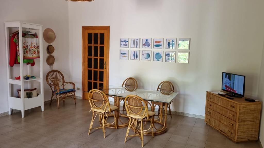 a dining room with a table and chairs and a television at La Villetta al Mare in Porto Cesareo