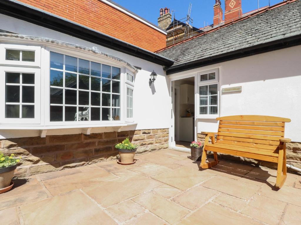 a wooden bench sitting outside of a house at The Mews Cottage in Lytham St Annes