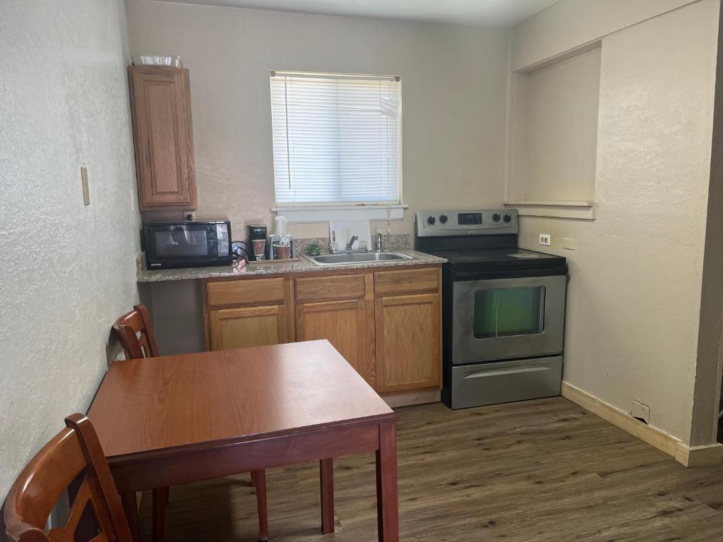 a kitchen with a table and a stove and a sink at Valley Motel in Alamosa