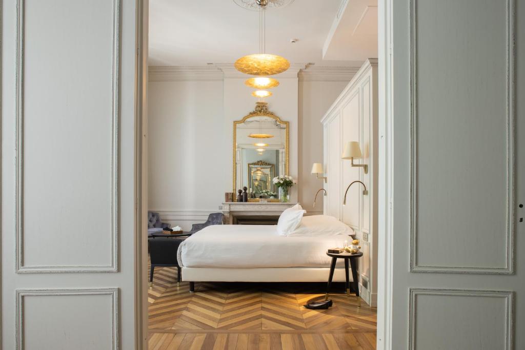 1 dormitorio con cama blanca y espejo en Villas Foch Boutique Hotel & Spa Bordeaux, en Burdeos