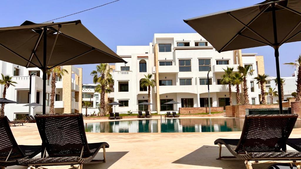 dos sillas y sombrillas frente a un edificio en Dominium Residence en Agadir