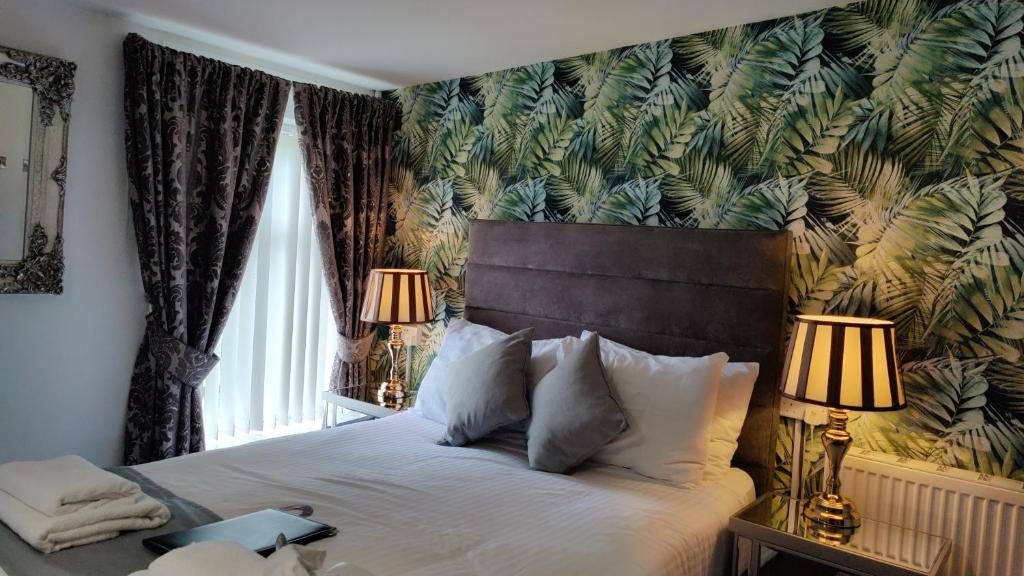 sypialnia z łóżkiem i tapetą w kolorze liściastym w obiekcie Number 43 w mieście Londonderry/Derry
