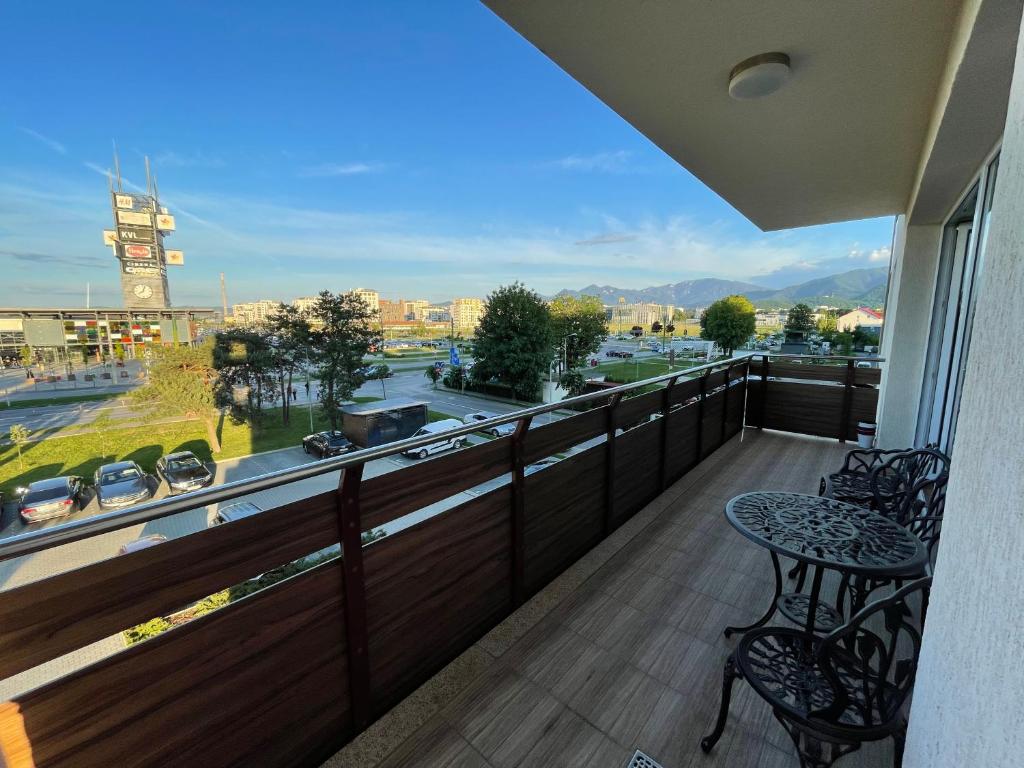 a balcony with a table and chairs and a view of a city at Coresi Long Stay Apartment in Braşov