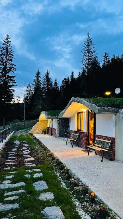 a small building with a bench in front of it at Resort Valea Tătarilor in Lacu Rosu